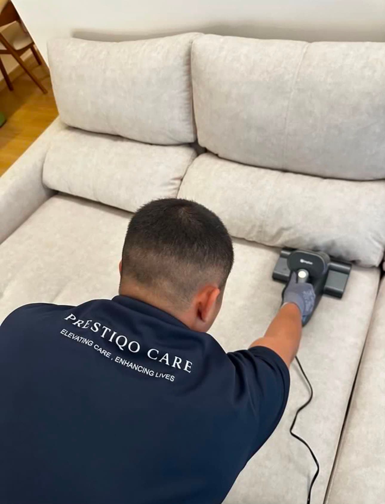 PrestiqoCare specialist deep-cleaning a sofa